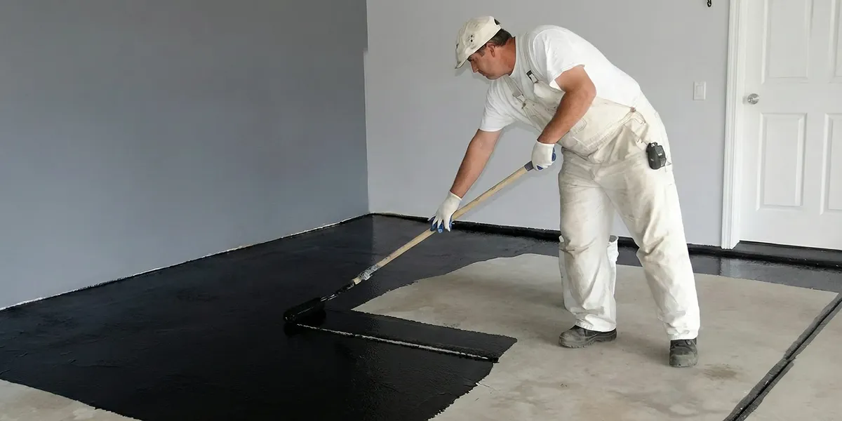 basement waterproofing professional applying waterproof coating to protect a basement floor in Orlando, FL